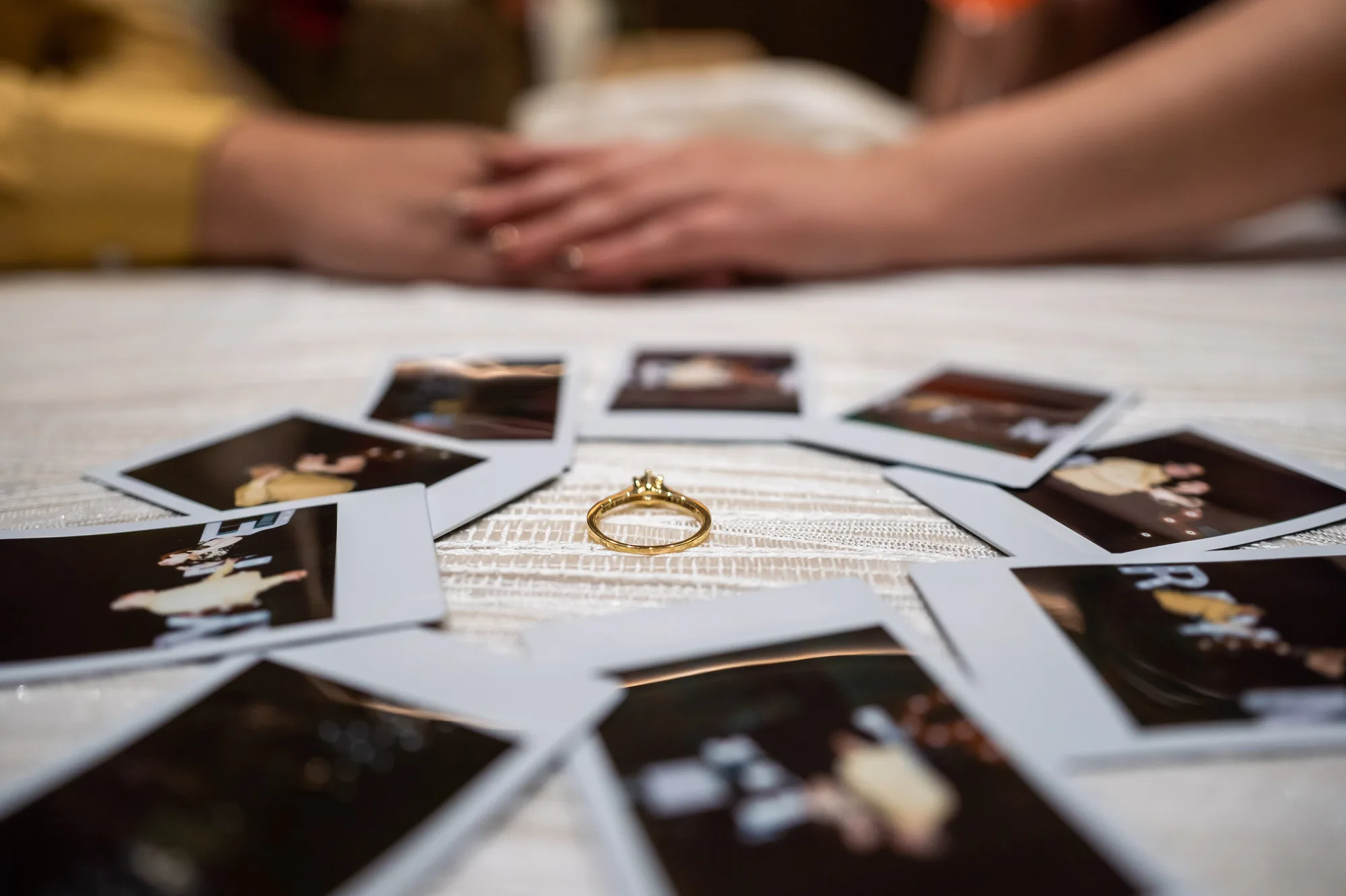 Anillo de compromiso rodeado de polaroids del evento