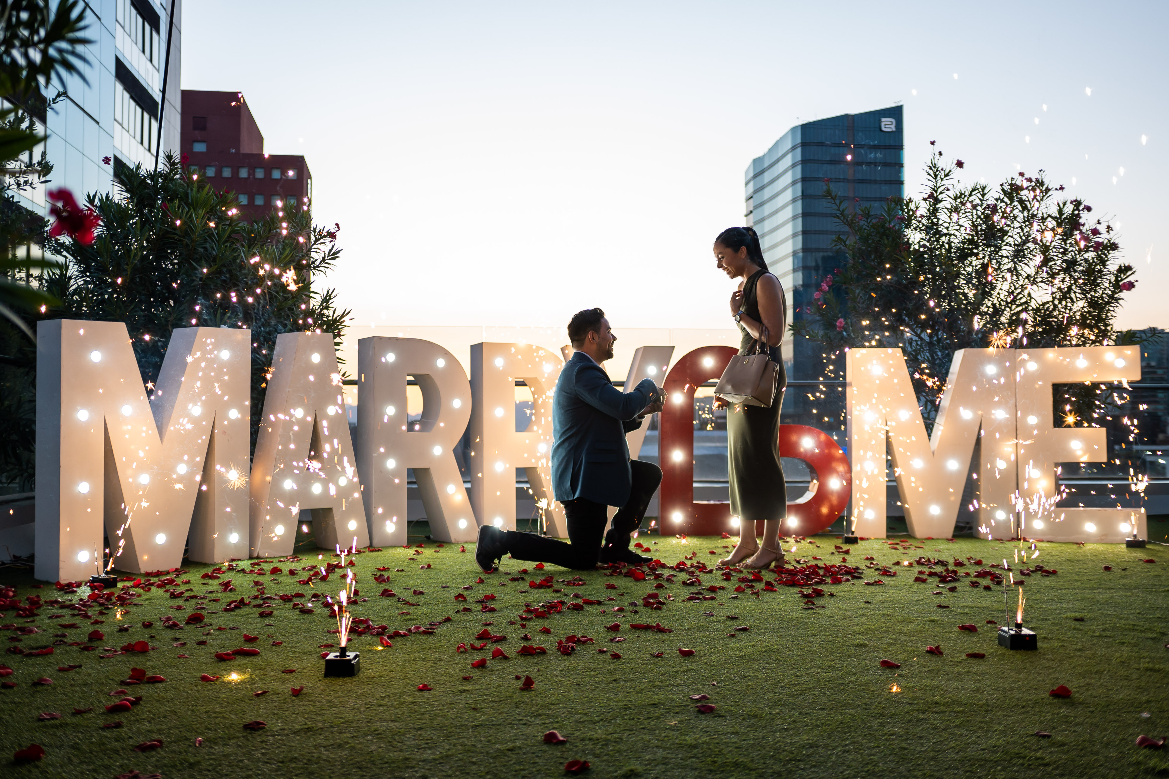 Pedida de mano con chisperos y letras MARRY ME iluminadas con vista a Monterrey