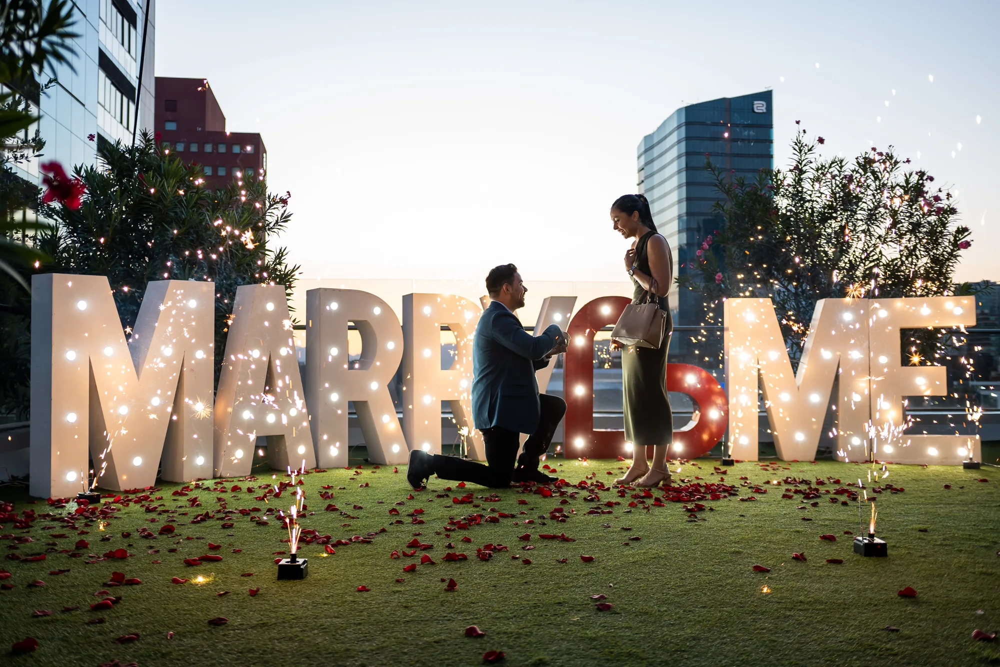 Pedida de mano con chisperos y letras MARRY ME iluminadas con vista a Monterrey