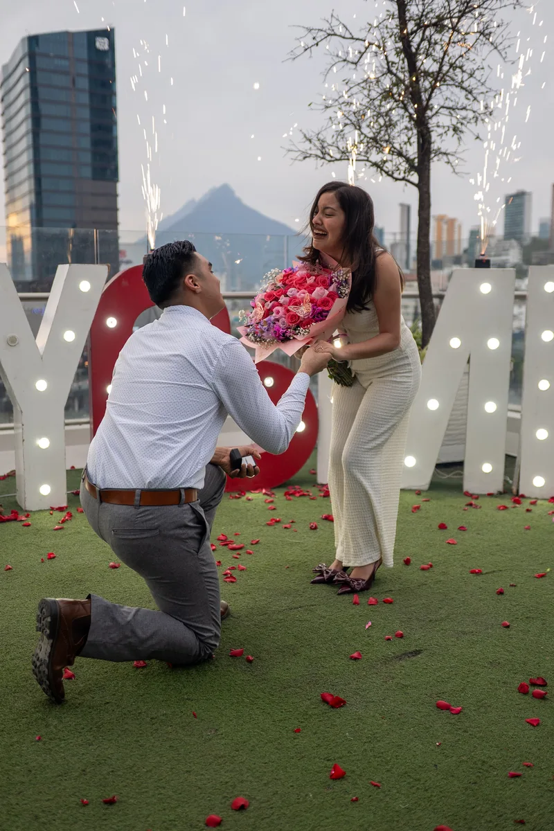 Pareja riendo a carcajadas frente al Cerro de la Silla en el momento de la pedida de mano